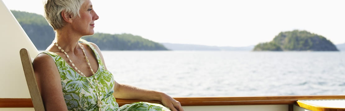 Woman relaxing on a boat overlooking open water, representing preparing for a long, comfortable, and fulfilling retirement through thoughtful planning.